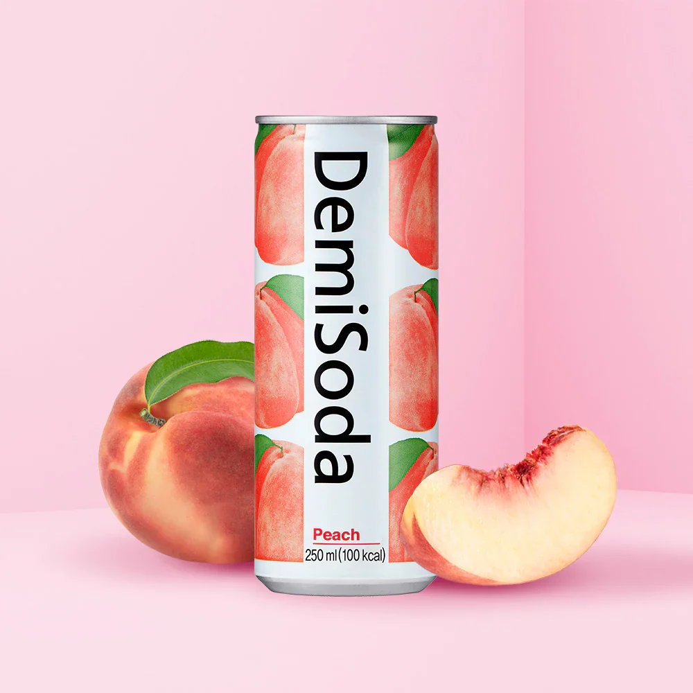 1_b0239859-bfb3-4f6f-b9c3-0213616a73b3 Peach-flavored Demisoda can with peach illustrations, surrounded by whole and sliced peaches on a pink background