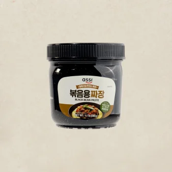 Jar of black bean paste labeled in Korean and English on a beige background.