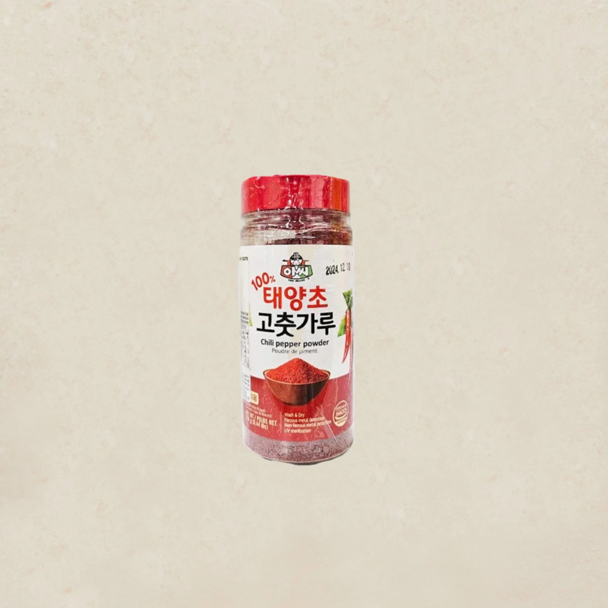 ASSI Red Pepper Powder 고춧가루 200g Red-capped bottle of chili pepper powder with a Korean label, placed against a beige background, isolated image.