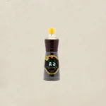 Bottle of Kadoya roasted sesame oil with a yellow cap, dark brown liquid visible through the neck, labeled 100% pure.