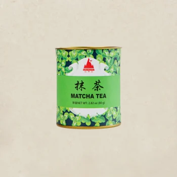 Cylindrical green tin can of matcha tea with leafy pattern and bold 'MATCHA TEA' label.
