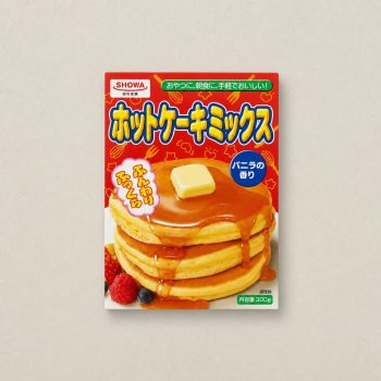 Box of Japanese pancake mix with a tall stack of syrupy pancakes topped by a pat of butter on a red package backdrop.