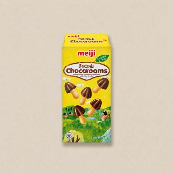 Meiji Chocorooms chocolate candy box (yellow) with mushroom-shaped biscuit pieces and ‘Sweet & Crispy’ label visible on the package, 40 g net weight edge of the image shown on a beige background.