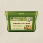 Green plastic tub labeled Korean Seasoned Soybean Paste, with a small image of vegetables on the label.