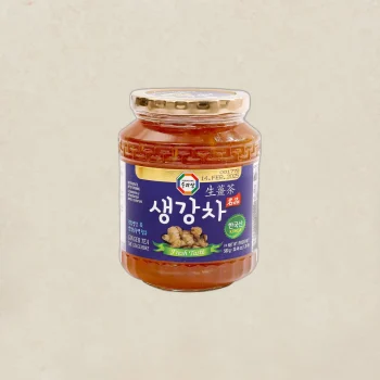 Jar of ginger tea with a blue label and gold lid, featuring Korean text and a 'Fresh Taste' ribbon on a beige background
