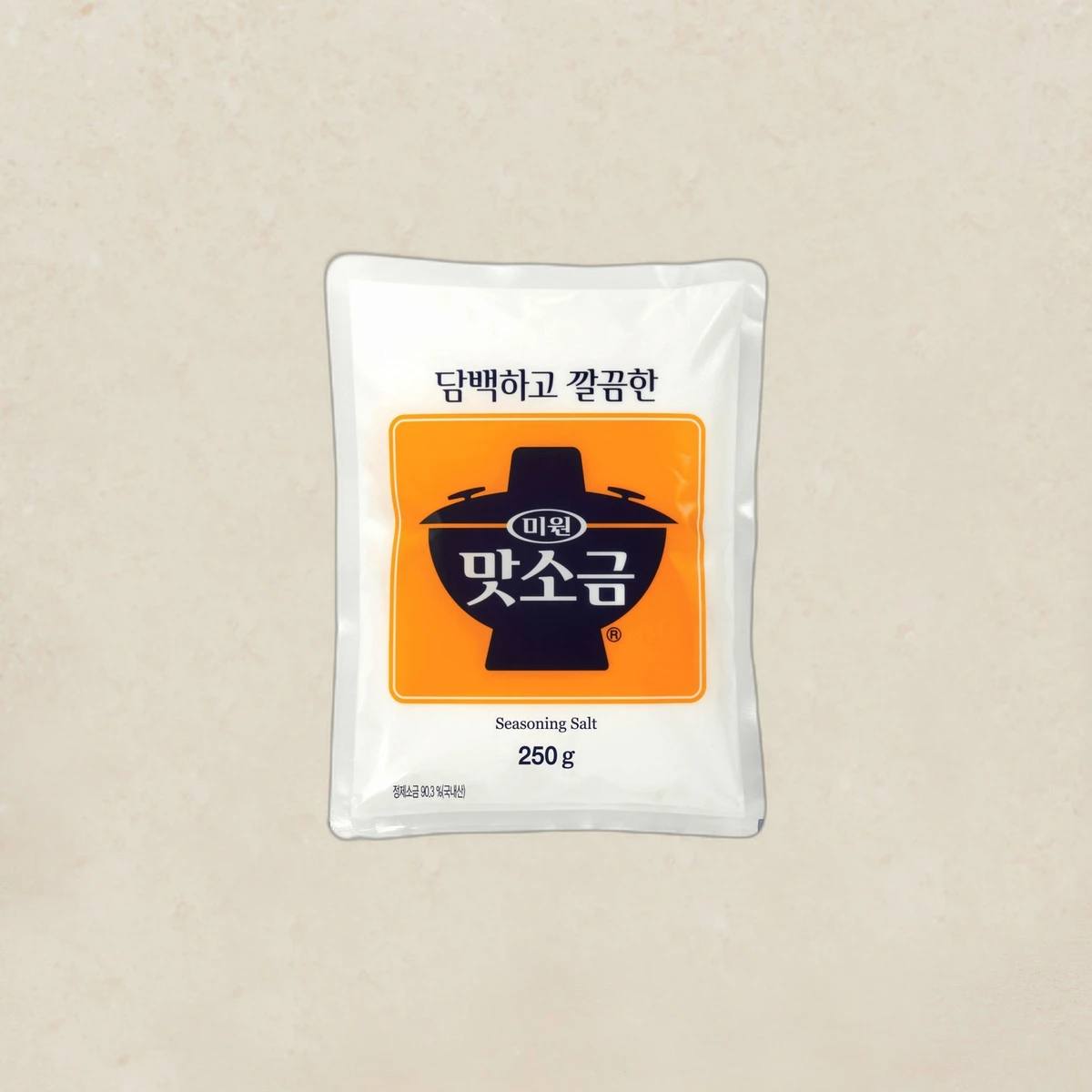 mall_ref657_1785774939.webp Bag of seasoning salt (250 g) with orange label and Korean text on a beige background.